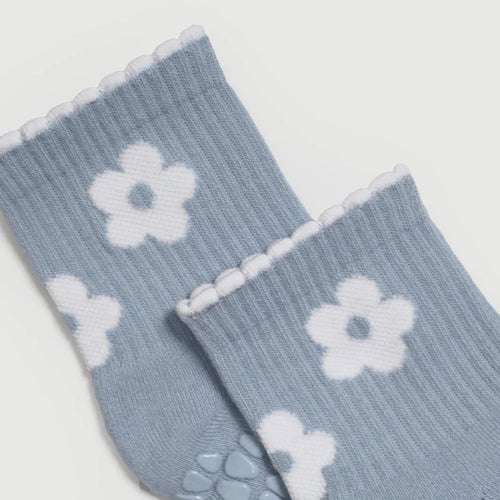 Light blue socks with white flower patterns on a light gray background
