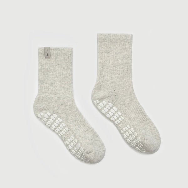 Pair of light gray socks with textured sole on a white background