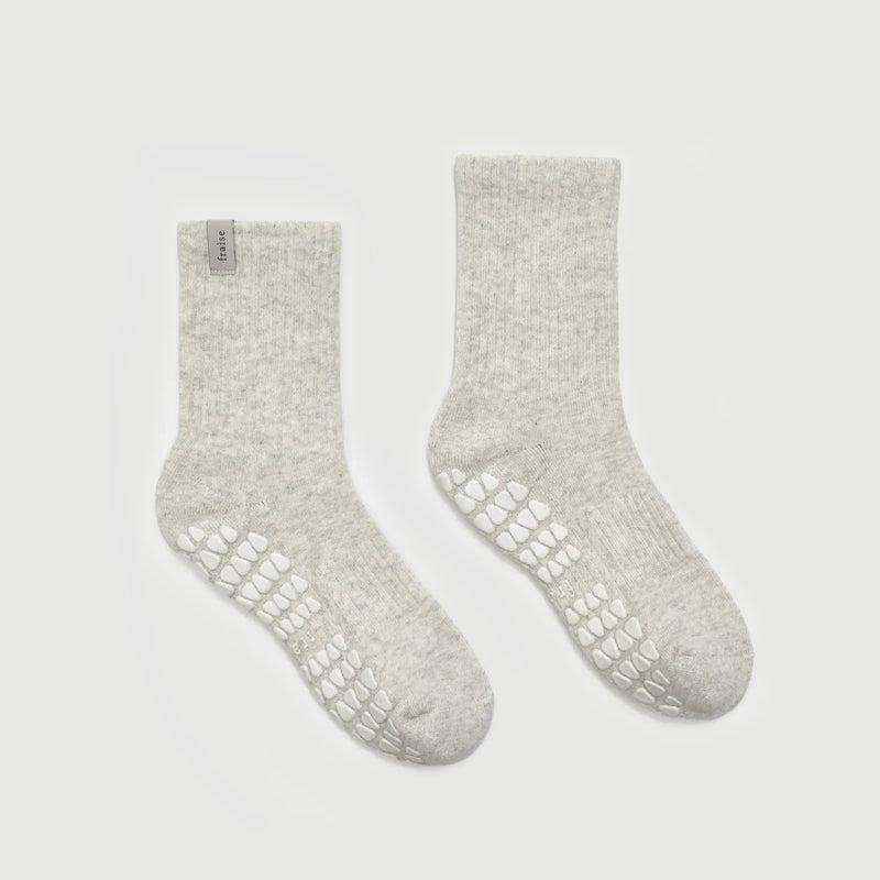 Pair of light gray socks with textured sole on a white background