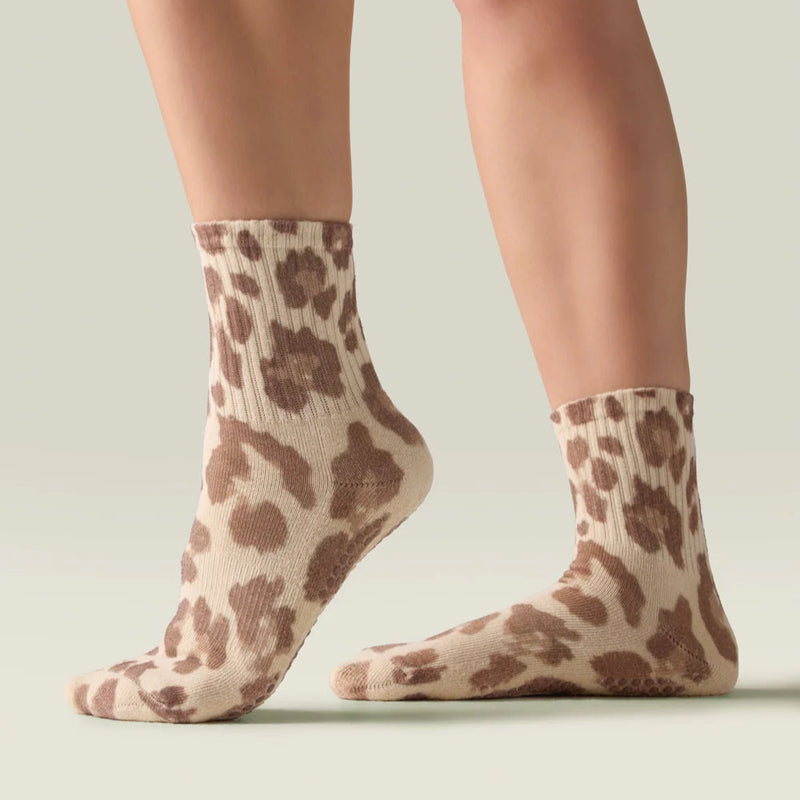 Leopard print socks worn by a person on a neutral background