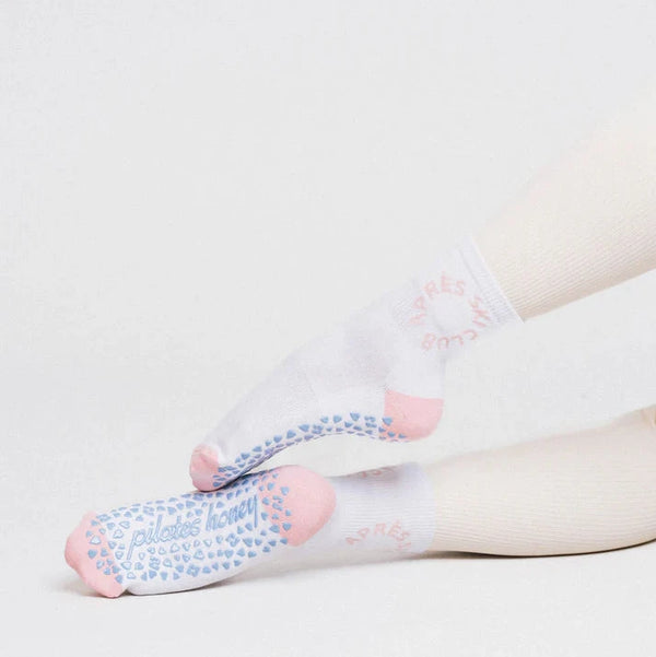 White socks with blue patterns worn by a person on a light gray background