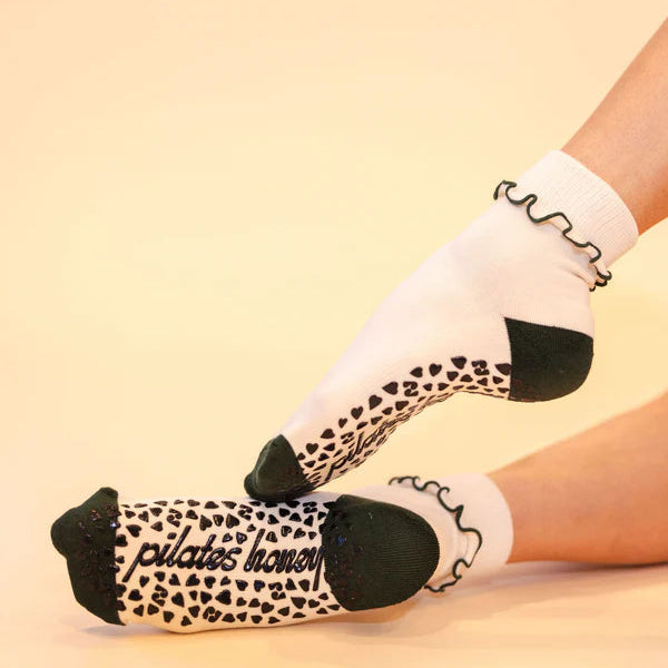White socks with black accents worn by a person on a beige background