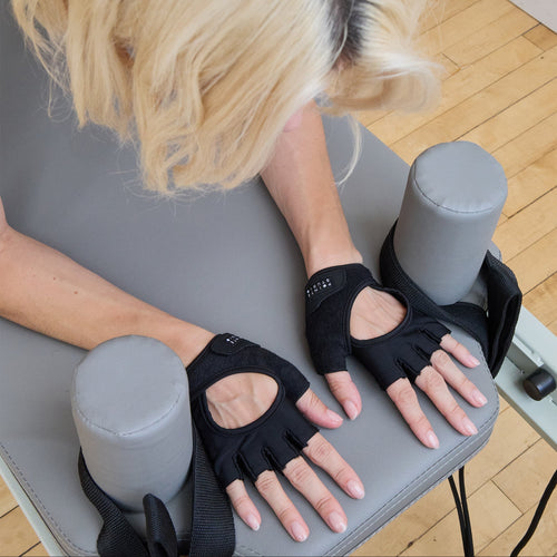 Person using hand exercisers on a wooden floor