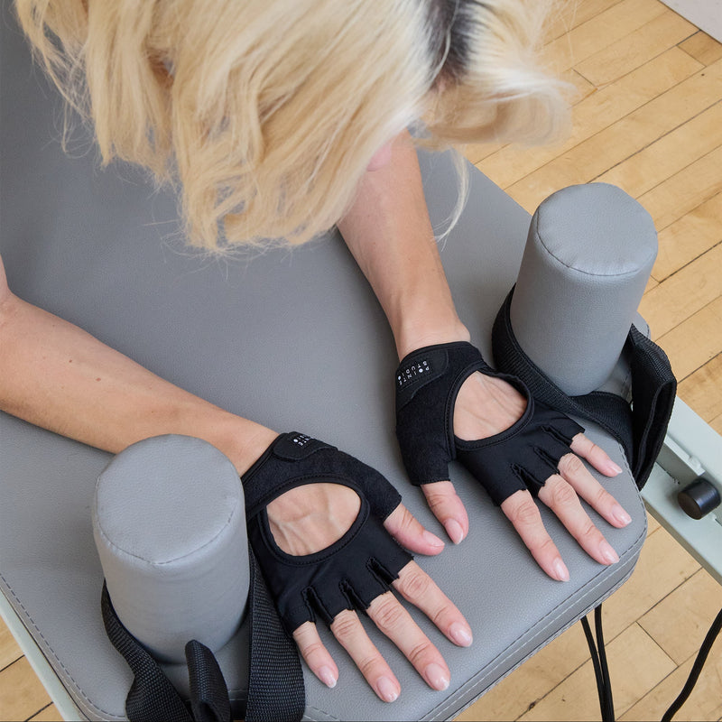 Person using hand exercisers on a wooden floor