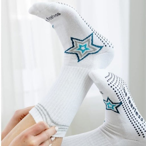 White socks with star designs held by a hand against a white background
