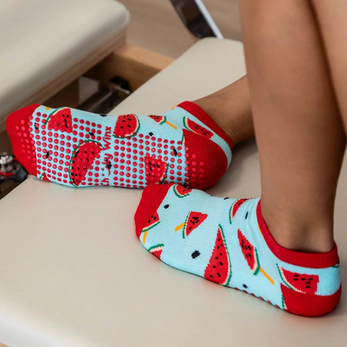 Person wearing socks with watermelon pattern on a chair
