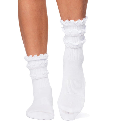 White ruffled socks worn by a person on a white background