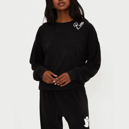Person wearing a black outfit with 'Boo' and ghost designs on a white background