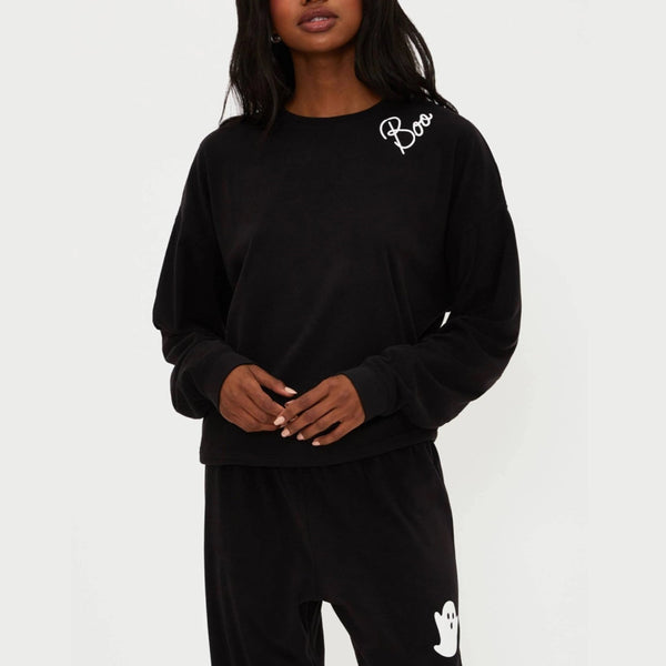 Person wearing a black outfit with 'Boo' and ghost designs on a white background