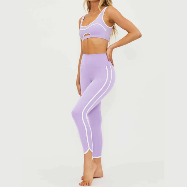 Person wearing a lavender sports bra and leggings set on a white background