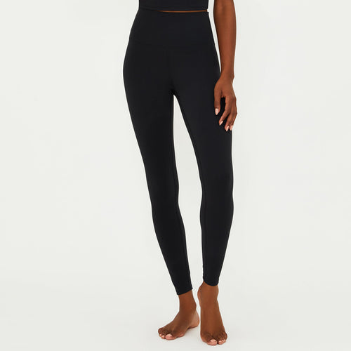 Woman wearing a black athletic outfit on a white background