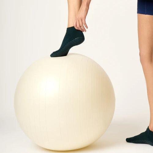 Person wearing black socks with a textured sole on a white background