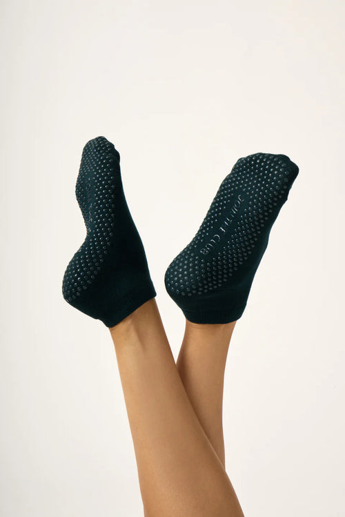 Dark Green textured socks worn on a person's feet against a light background