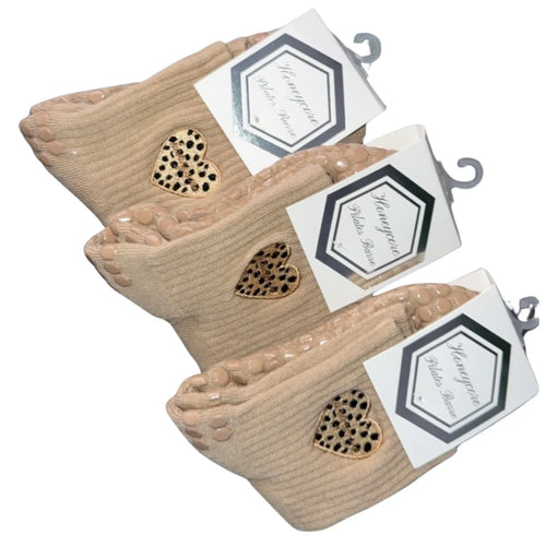 Set of three beige foot-shaped soaps with gold heart designs on a white background