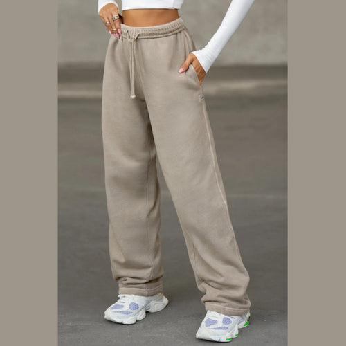 Person wearing beige sweatpants with a plain background