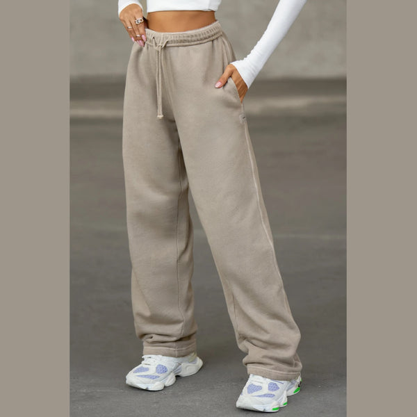 Person wearing beige sweatpants with a plain background