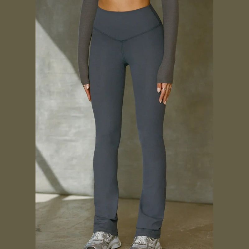 Person wearing navy leggings and a long-sleeve top against a neutral background