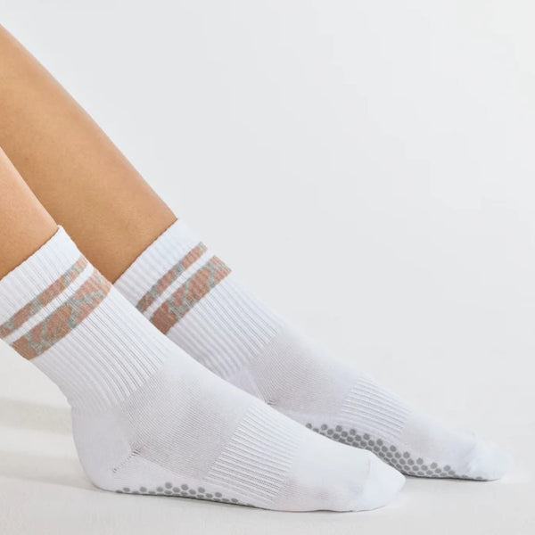 White socks with gray stripes worn by a person on a light background