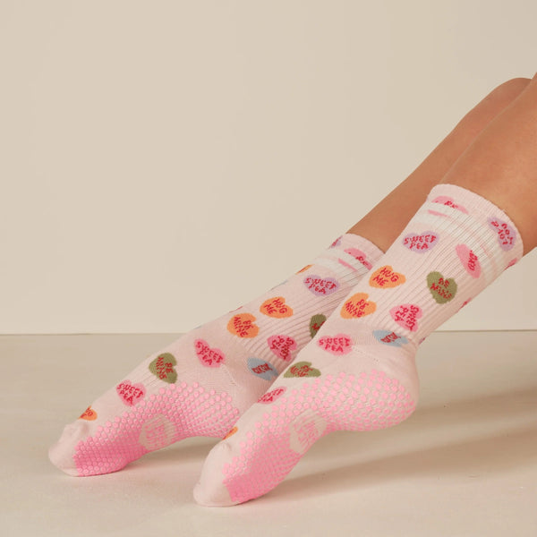 Pink socks with floral pattern worn by a person on a beige background