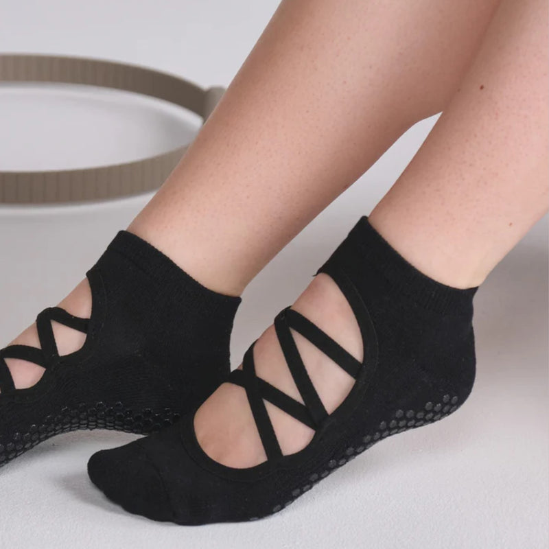 Black socks with criss-cross design worn by a person on a light background