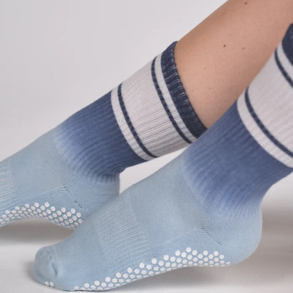 Light blue socks with white stripes and textured sole on a light gray background