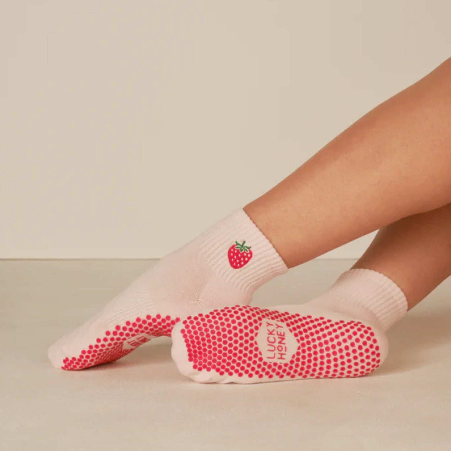 White socks with red pattern and strawberry design on a beige background