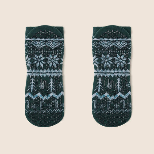 Pair of green socks with fair isle pattern on a beige background