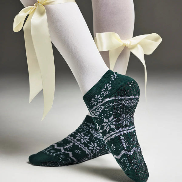 Green patterned socks with white bows on a neutral background