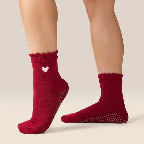 Red socks with a heart design on a beige background