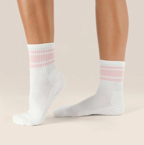 White socks with pink stripes worn by a person on a beige background