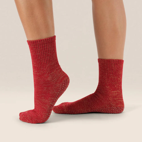 Red textured socks worn by a person on a beige background