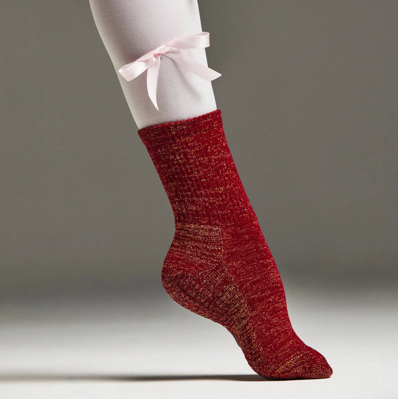 Red textured sock worn by a person on a neutral background