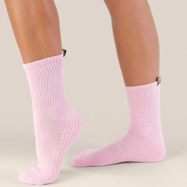 Pink socks worn by a person on a neutral background