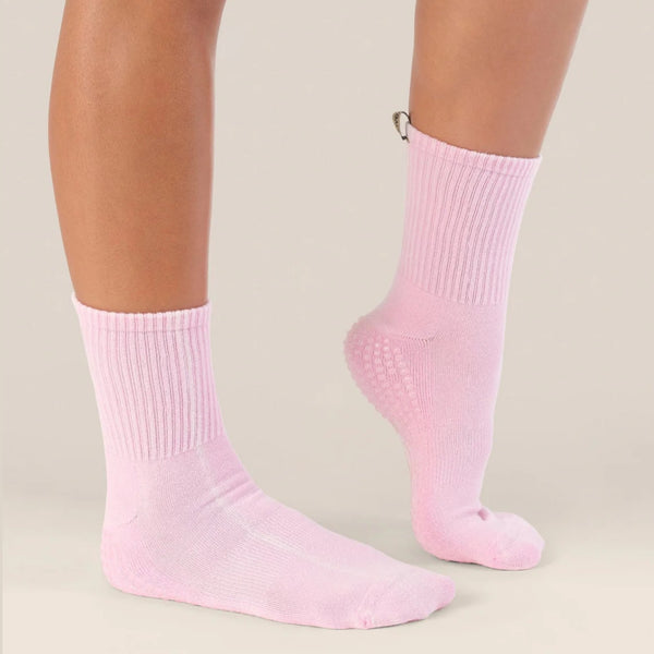 Pink socks worn by a person on a beige background