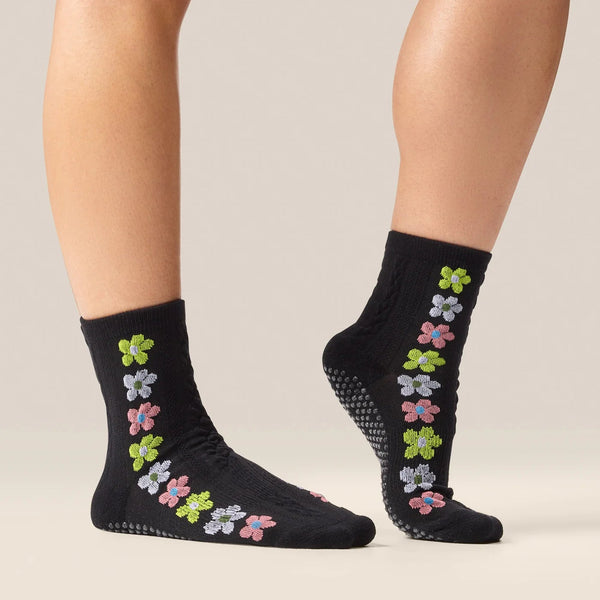 Black socks with colorful floral patterns on a neutral background