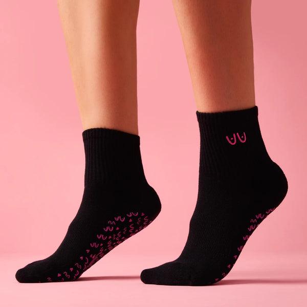 Black socks with pink patterns on a pink background