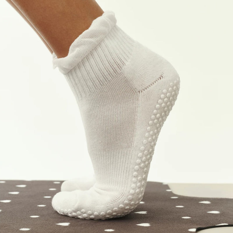 White ankle sock with textured sole on a neutral background