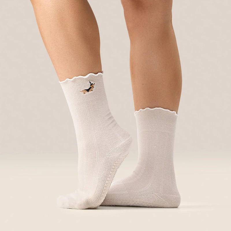 White socks with a small design on the leg against a neutral background