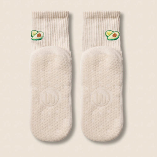 Pair of cream-colored socks with avocado design on a beige background