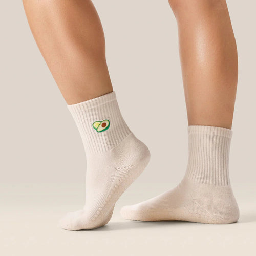 White socks with avocado design worn by a person on a neutral background