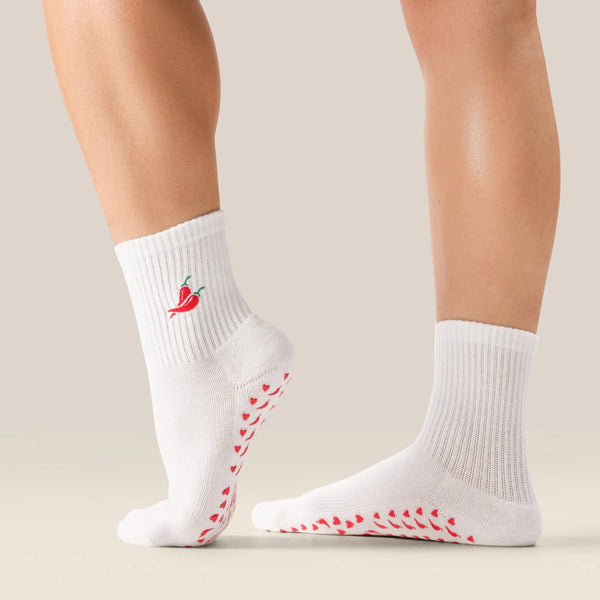 White socks with red chili pepper design and sole pattern on a neutral background