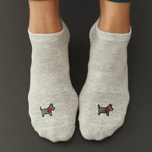 Gray socks with dog embroidery on a dark background