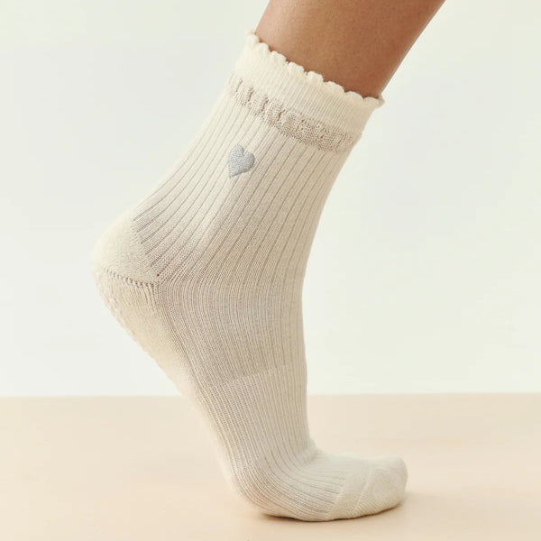 Beige sock with a heart detail on a light background