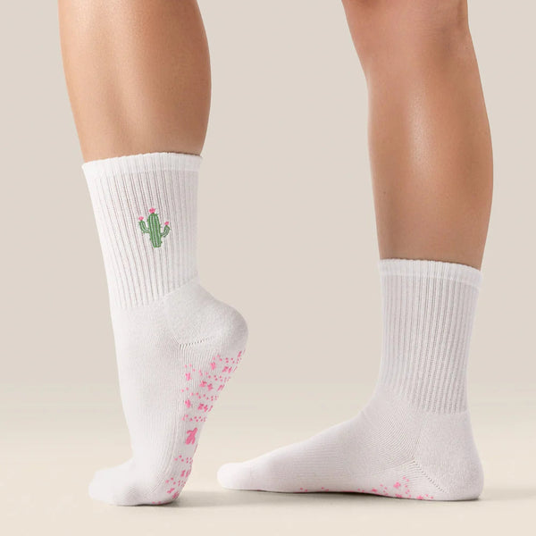 White socks with cactus design and pink flower pattern on a neutral background