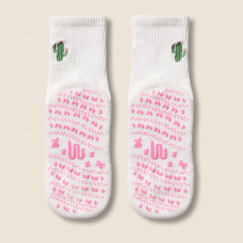 Two socks with pink patterns and cactus designs on a beige background