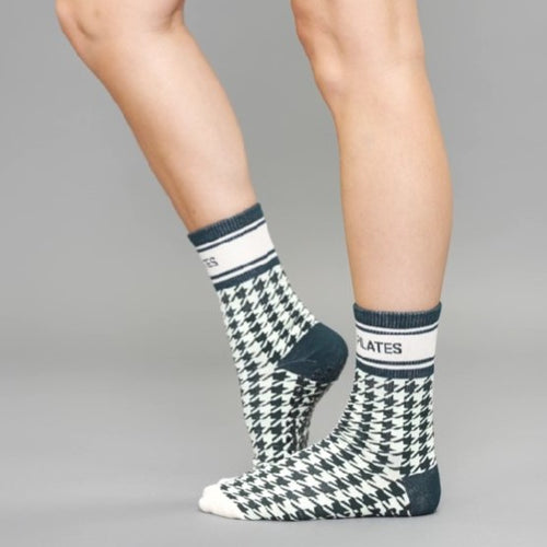 Houndstooth patterned socks with brand name on a neutral background