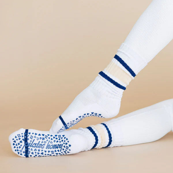White socks with blue stripes and text worn by a person on a beige background