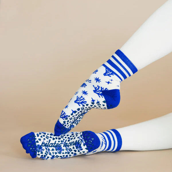 White socks with blue floral patterns and stripes on a beige background
