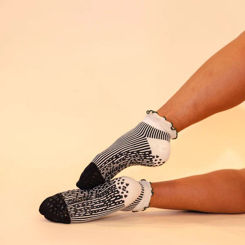 Person wearing black and white patterned socks on a beige background