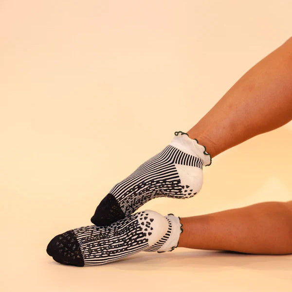 Person wearing black and white patterned socks on a beige background